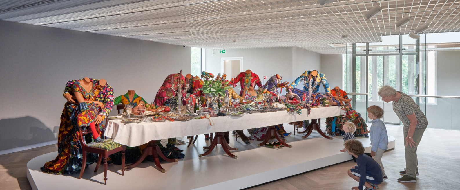 Bij het kunstwerk van Yinka Shonibare (1962) in het LAM Museum klotst de wijn uit de glazen, rollen de flessen champagne over de grond, wordt er gevochten om zout en viert de liefde hoogtij. Bij het kunstwerk van Yinka Shonibare (1962) in het LAM Museum klotst de wijn uit de glazen, rollen de flessen champagne over de grond, wordt er gevochten om zout en viert de liefde hoogtij.